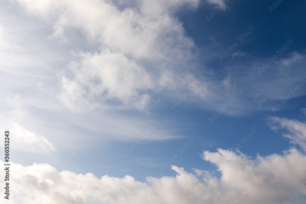Mix of hard and soft white clouds in blue sky