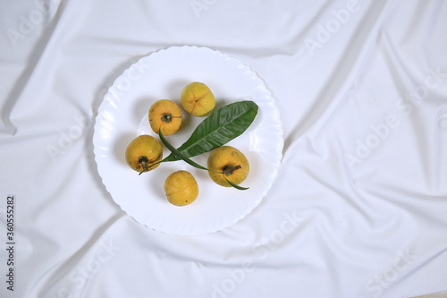 Wallpaper Mural Fresh tasty eggfruit with leaves on a white bowl Torontodigital.ca