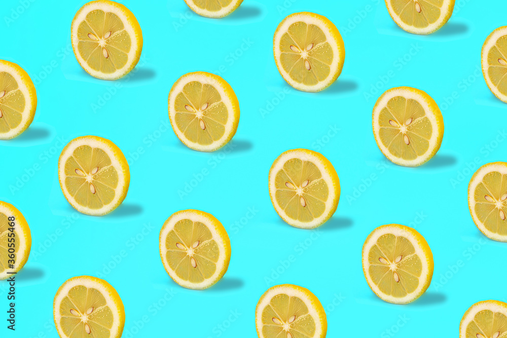 Tropical pattern of lemon citrus wheel on green mint color background.