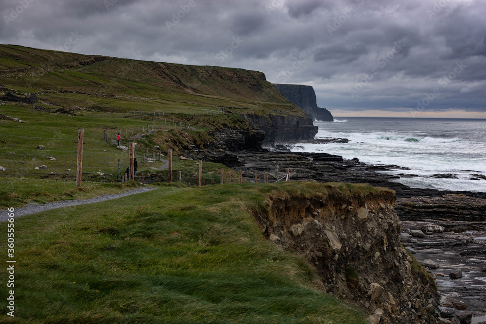 Landscape of coastal cliff walk on a stormy, cloudy day with rough sea in Doolin, Co. Clare, Ireland. Wild Atlantic Way.