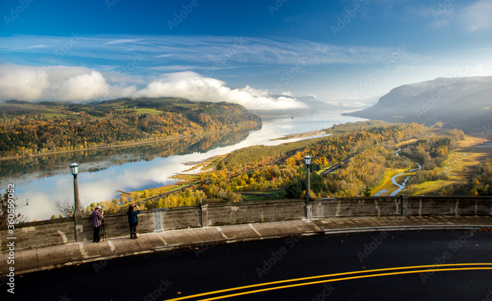 man and woman photographing the fall color in the Columbia River Gorge National Scenic Area. Location is Crown Point, view is looking east.  Calm wind allows reflections which are seldom seen.