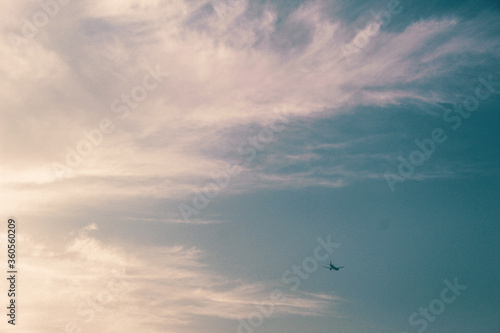 plane flying between clouds in a blue sky