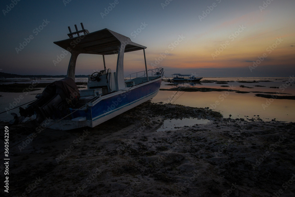 Two boats stranded on sand at dusk, Nusa Lembongan, Bali