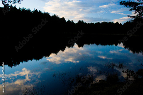 Reflejos y atardecer sobre lago en bosque de montaña © drakis