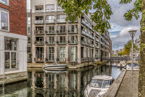 Photography Waterfront apartments with boats at quayside in the calm canal