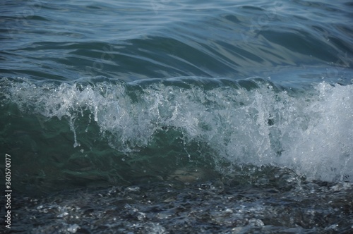 Bluish transparent sea wave with white foam