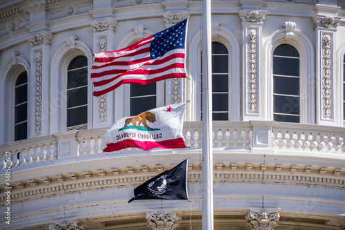 The US flag, the California flag and the POW-MIA flag waving in the wind in front of the Capitol State Building in downtown Sacramento photo