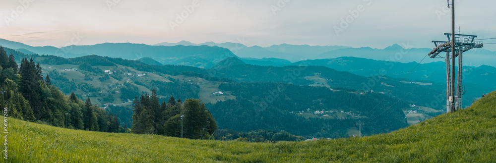 Early evening panorama of ski slope at Stari Vrh, Slovenia. View over low hills and evening sky.