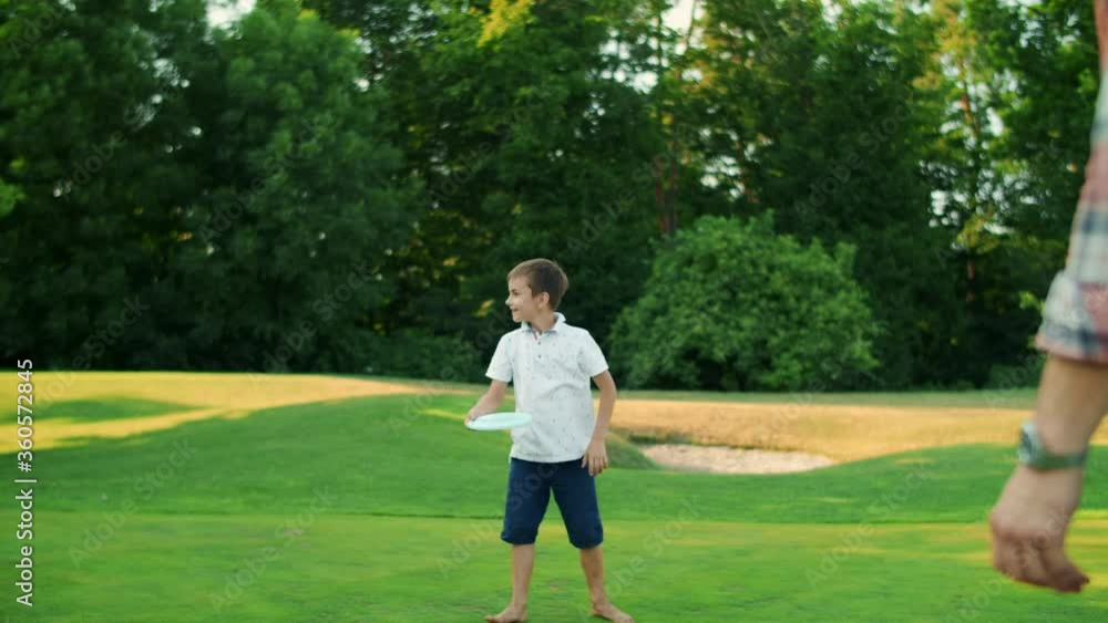 Man, boy and woman playing frisbee in park. Family throwing frisbee disc Man, boy and woman playing frisbee in park. Family throwing frisbee disc