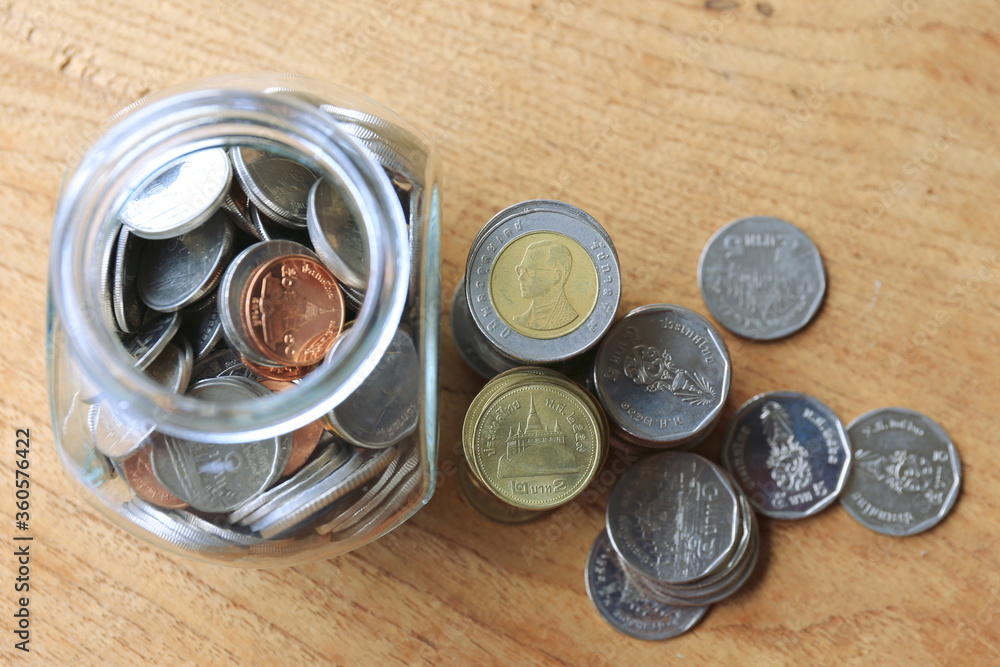 Close-up of many Thai baht coins on a wooden floor selective focus and shallow depth of field Close-up of many Thai baht coins on a wooden floor selective focus and shallow depth of field