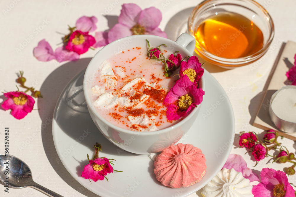 Pink moon milk with spices, marshmallows and wild rose flowers. Close up Pink moon milk with spices, marshmallows and wild rose flowers. Close up