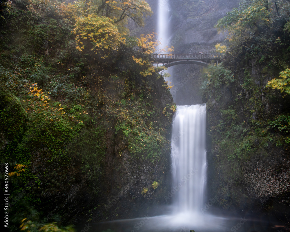 Fototapeta premium Long exposure a Multnomah waterfalls, Oregon, U.S.A., featuring fall colors and haze from the water