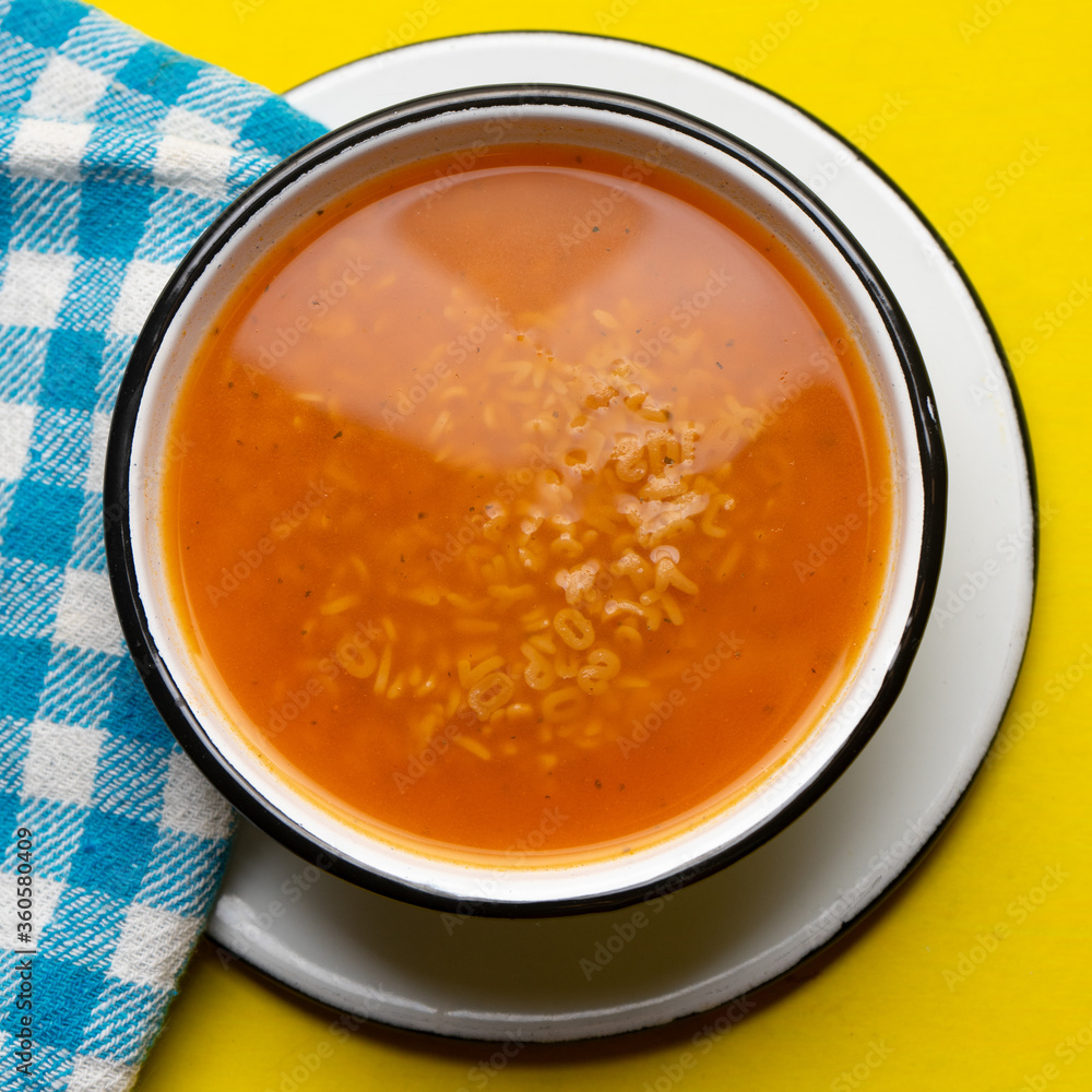 Alphabet soup pasta on yellow background Alphabet soup pasta on yellow background
