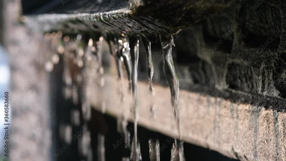 Slow motion video Water droplets flowing down to the stone Slow motion video Water droplets flowing down to the stone