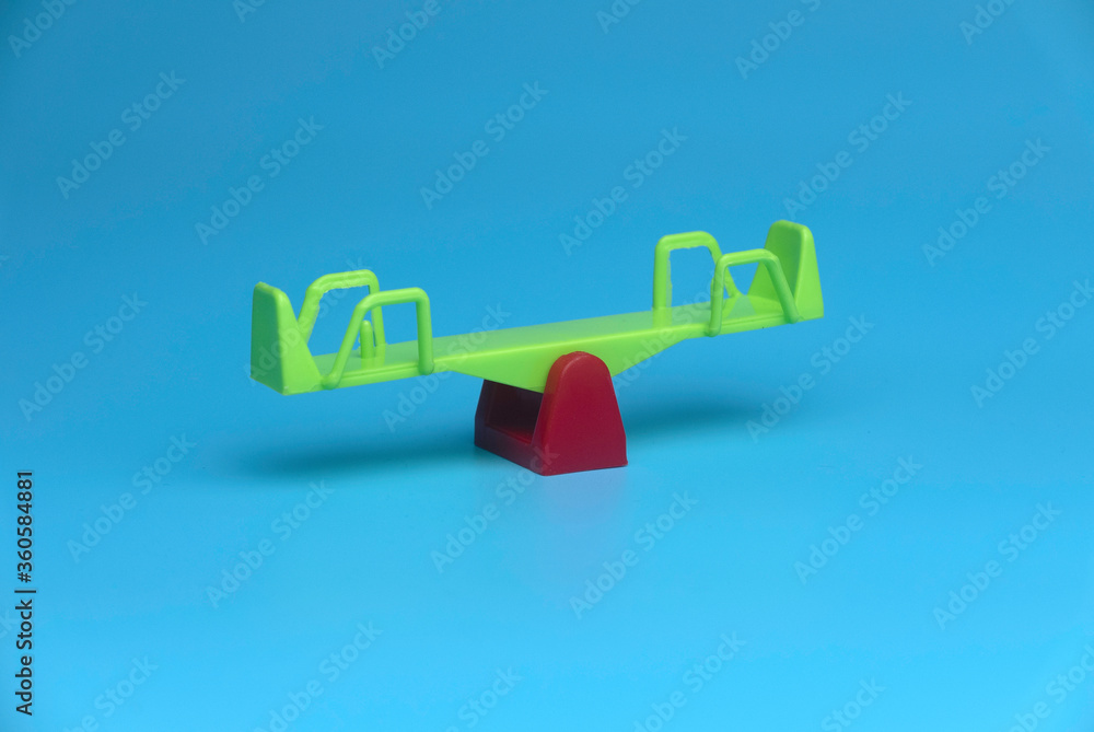Selective focus of toy seesaw isolated on a blue background. Selective focus of toy seesaw isolated on a blue background.