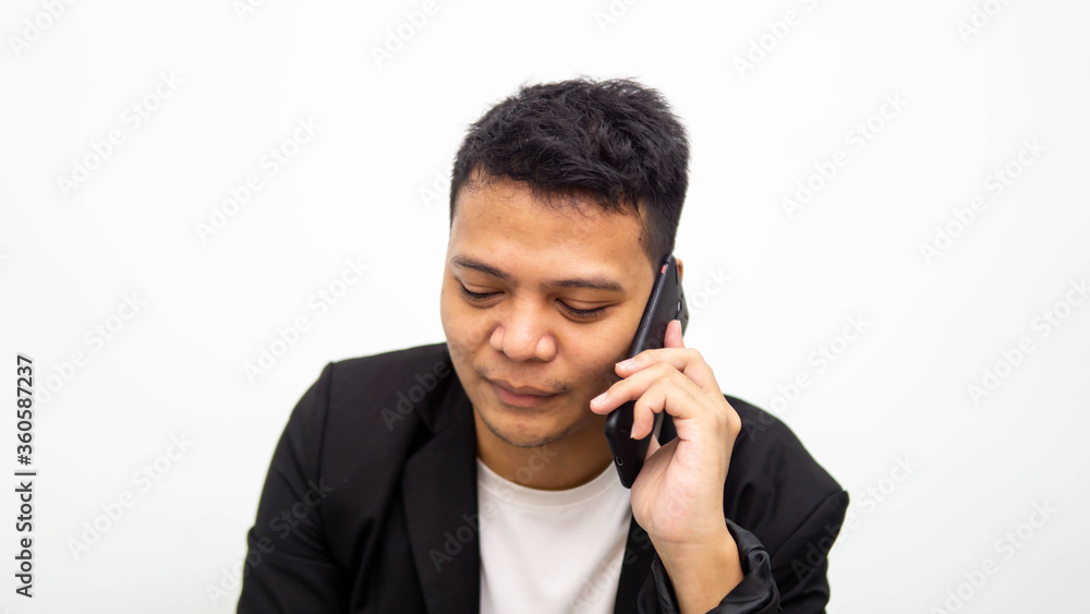 A portrait of young Asian businessman having a serious talk and conversation on the phone with isolated white background. Career business job concept. A portrait of young Asian businessman having a serious talk and conversation on the phone with isolated white background. Career business job concept.