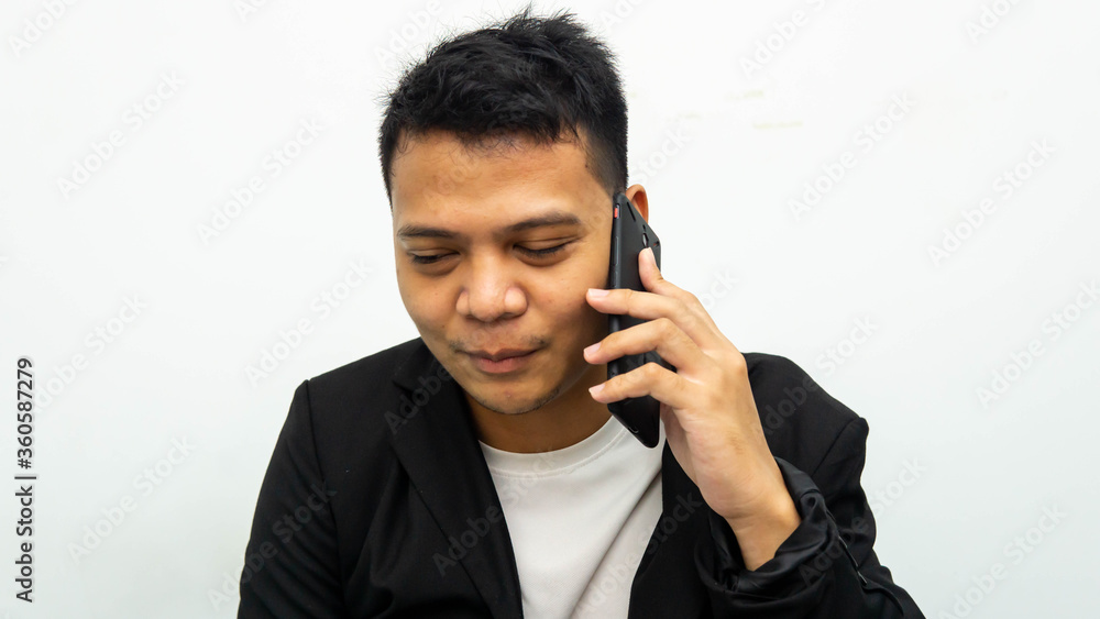 A portrait of young Asian businessman having a serious talk and conversation on the phone with isolated white background. Career business job concept. A portrait of young Asian businessman having a serious talk and conversation on the phone with isolated white background. Career business job concept.