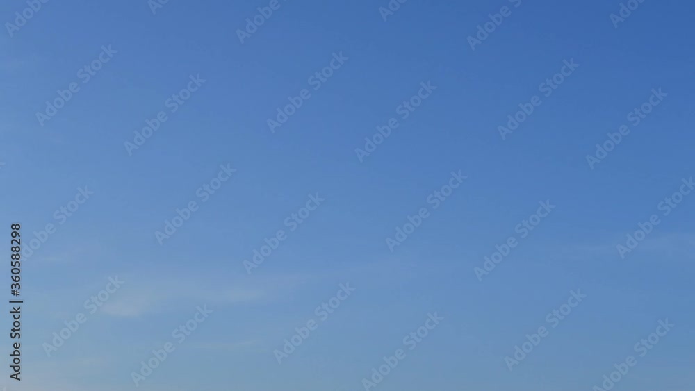 TimeLapse of Sunny wispy blue sky with minimal white cirrus or cirrostratus clouds & fluffy cumulus cloudscap slowly moved on morning sunrise or evening twilight horizon in tropical summer sunlight TimeLapse of Sunny wispy blue sky with minimal white cirrus or cirrostratus clouds & fluffy cumulus cloudscap slowly moved on morning sunrise or evening twilight horizon in tropical summer sunlight