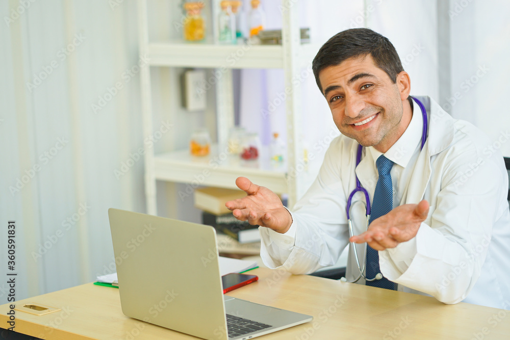 Smiling doctor posing in the office, he is wearing a stethoscope.