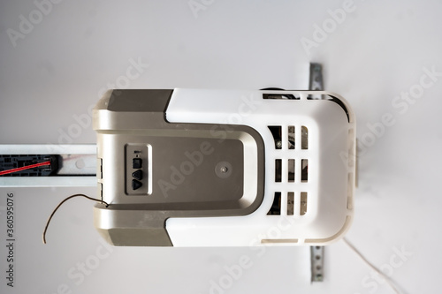 Upward angle looking at the motor box for a garage door opener pulley system