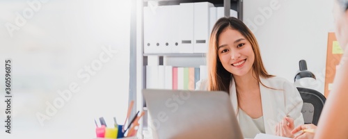 Asian beautiful empower woman smiling with friend working at meeting room in office interior background with copy space.Owner businesswoman startup with confident and cheerful.