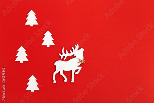 White wooden figure of deer with big horns in fir tree forest. Concept for New Year or Merry Christmas. Christmas Holiday background.