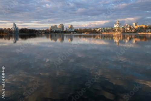 city reflected in a pond with clouds