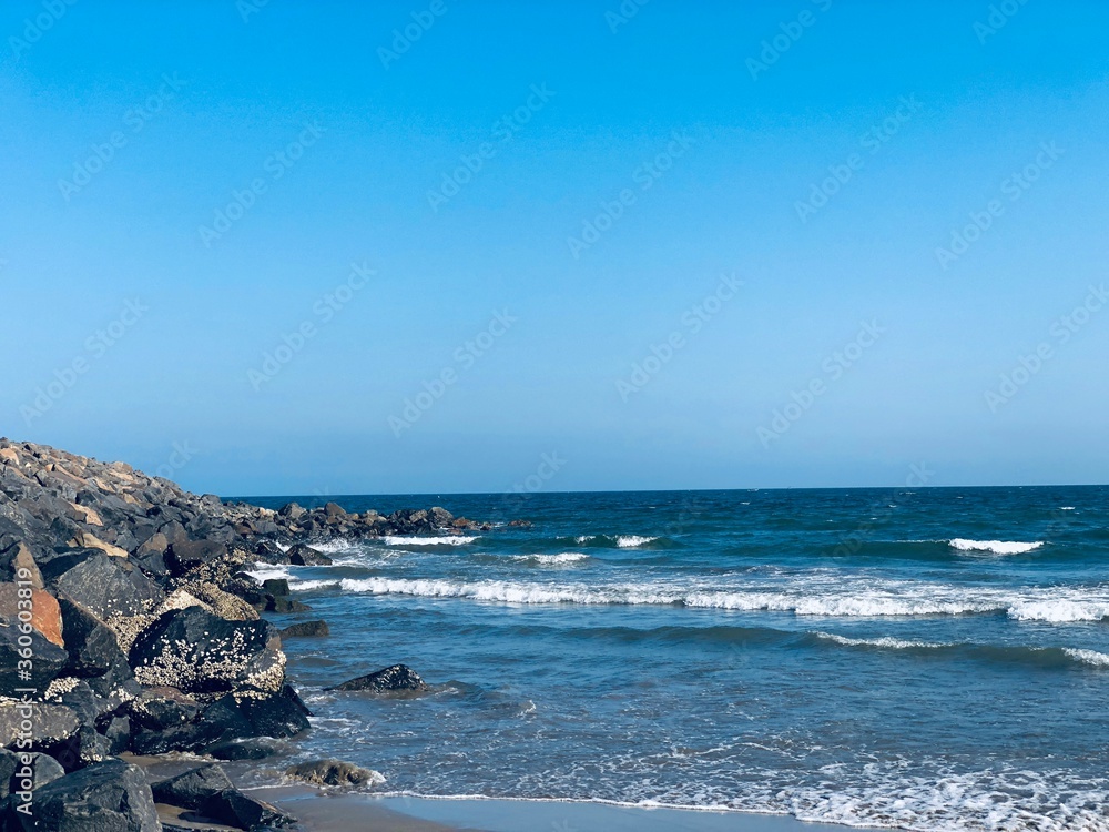 Sea waves on the beach with rocks on the shore at Ennore beach, Tamil nadu