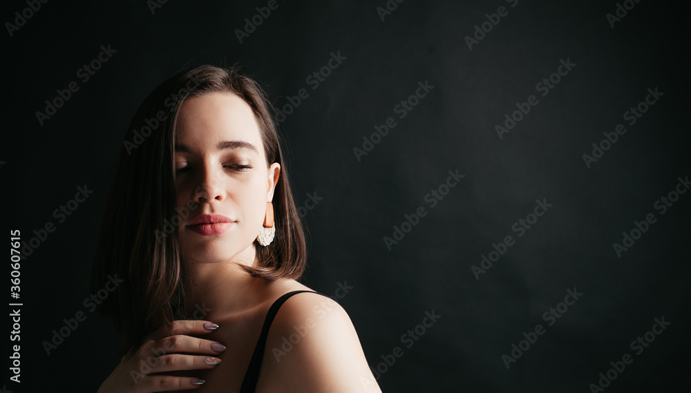 beautiful model portrait of a girl with dark hair and a black T-shirt on a black background beautiful model portrait of a girl with dark hair and a black T-shirt on a black background