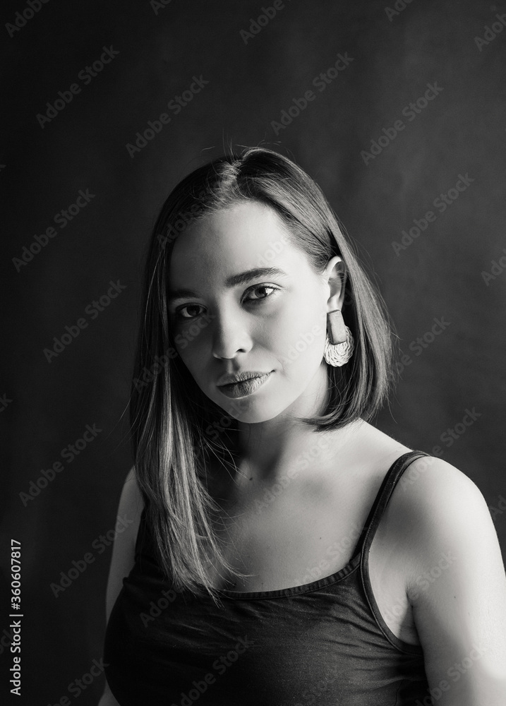Naklejka premium portrait of a girl in black and white photography. girl on a dark background. model portrait