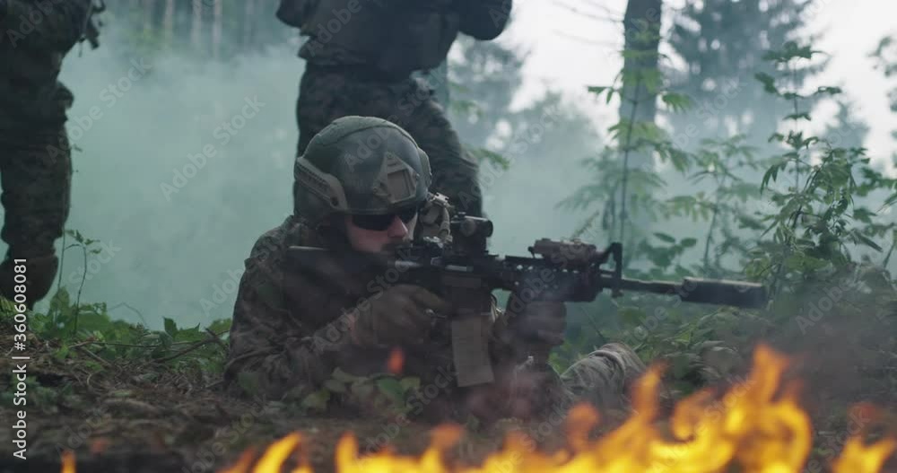 Soldiers using special equipment, weapons and tactical devices and moving through fire and smoke Soldiers using special equipment, weapons and tactical devices and moving through fire and smoke