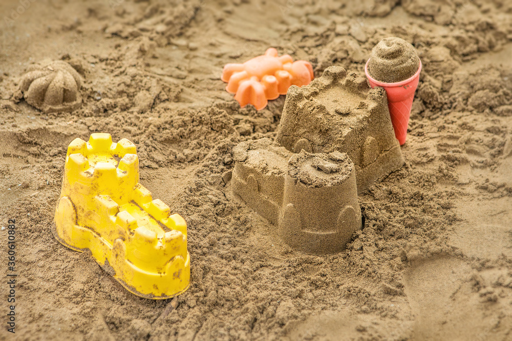 Children's sand toys. Plastic childs pattypans with sand objects. Colorful sand cheese moulds with sand forms Children's sand toys. Plastic childs pattypans with sand objects. Colorful sand cheese moulds with sand forms