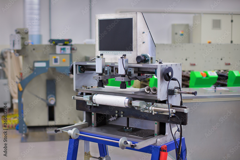 Flexo Plate Mounting Machine in printing hall. Printing press is in the background. Flexo Plate Mounting Machine in printing hall. Printing press is in the background.