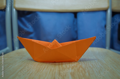 Leadership concept with blue paper ship leading among wooden . Blue paper boat on wooden background . Origami paper ship .