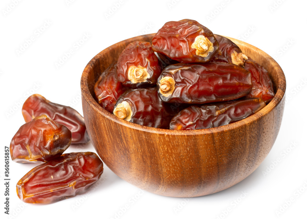 dried date palms in the wooden bowl, isolated on white background