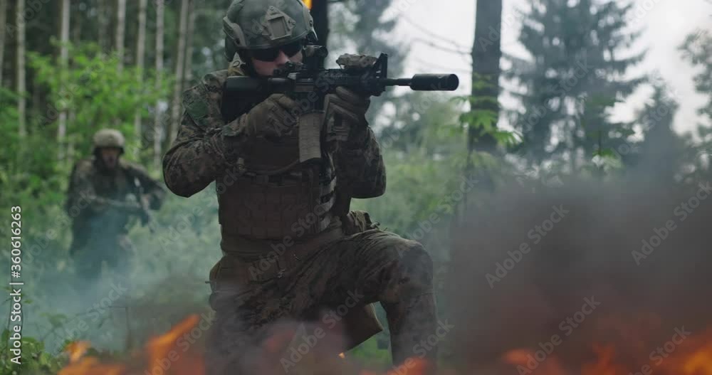 Soldiers using special equipment, weapons and tactical devices and moving through fire and smoke Soldiers using special equipment, weapons and tactical devices and moving through fire and smoke