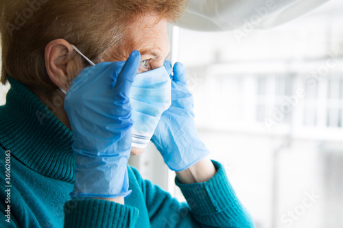 portrait of senior woman with disposable medical mask. Safety in public places during coronavirus outbreak. photo