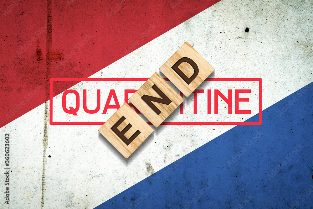 Obraz premium End of quarantine. The inscription on wooden blocks on the background of the flag of Netherlands. The end of the pandemic. Business. T