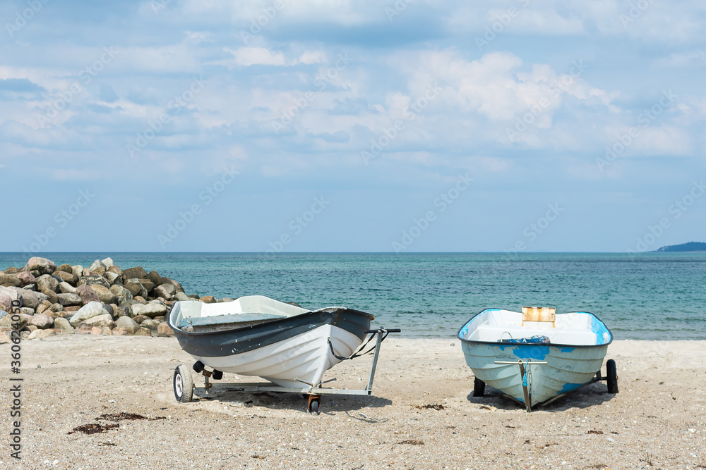 Boats on a sandy beach, against the background of the sea. North Sea. Denmark. Water transport. Boats on a sandy beach, against the background of the sea. North Sea. Denmark. Water transport.
