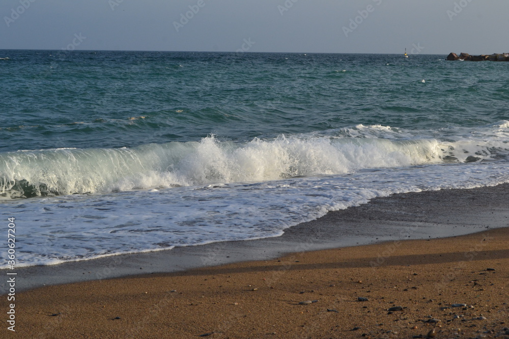 small waves of the Mediterranean Sea roll ashore from pebbles and stones in the afternoon small waves of the Mediterranean Sea roll ashore from pebbles and stones in the afternoon
