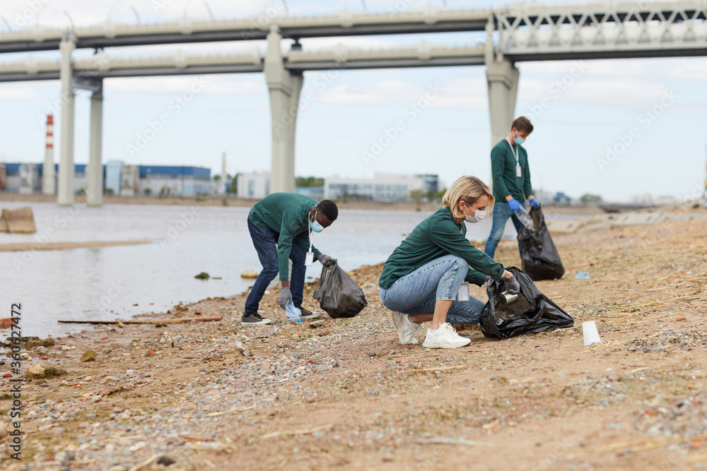 Group of volunteers cleaning the bank of the river from the garbage Group of volunteers cleaning the bank of the river from the garbage