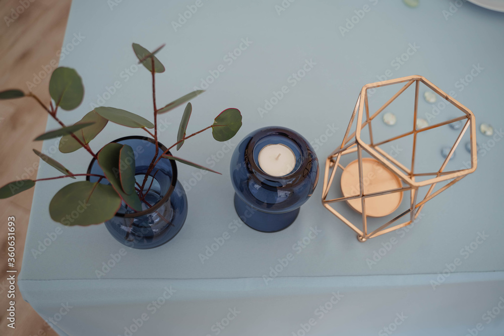 blue candlestick with a candle and a small vase blue candlestick with a candle and a small vase