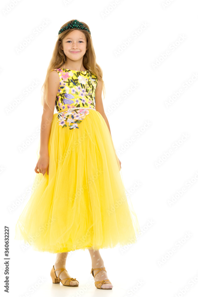 A little girl in a long, elegant dress of a princess.