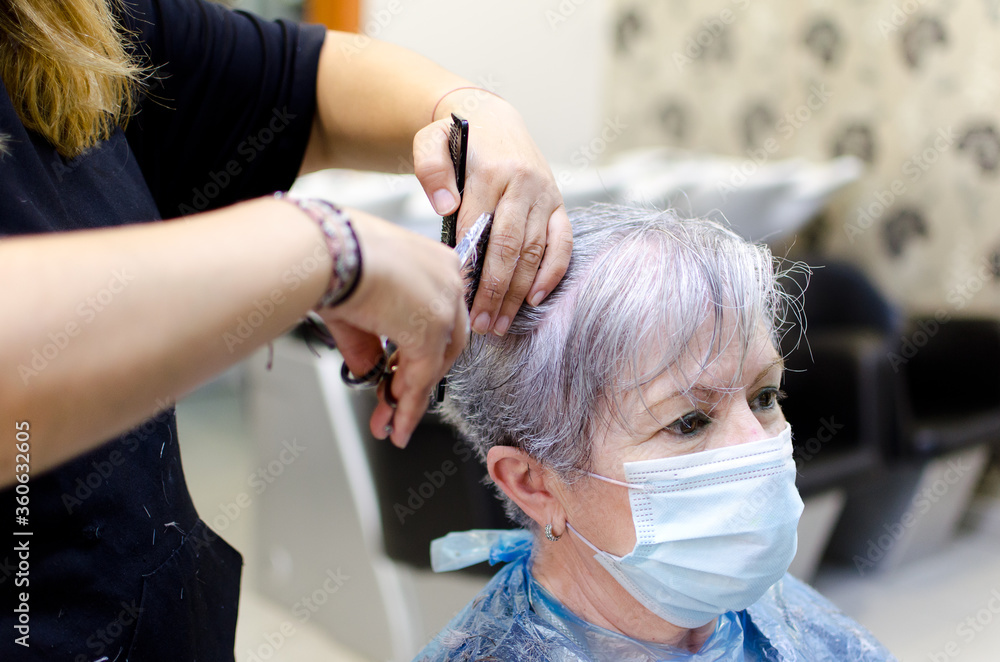 Mujer mayor cortándose el pelo en una peluquería con mascarilla para evitar  coronavirus Stock Photo | Adobe Stock