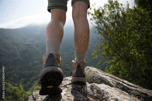 Successful hiker enjoy the view on mountain top cliff edge
