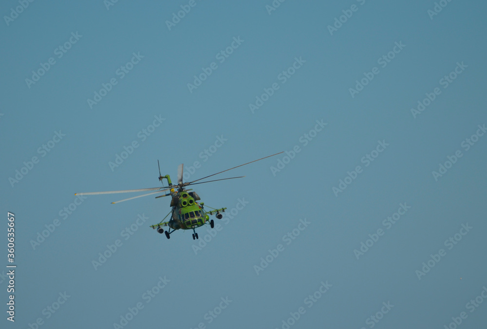 Fototapeta premium Military helicopter in blue sky, space transport photo