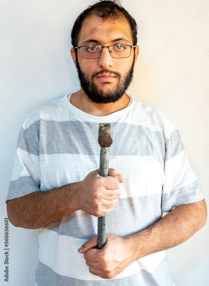 Arabic man holding a hammer infont of his chest Arabic man holding a hammer infont of his chest