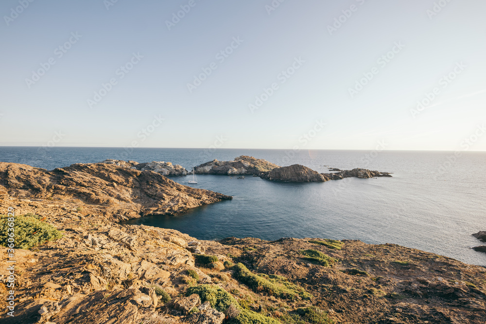 A rocky shore next to a body of water A rocky shore next to a body of water