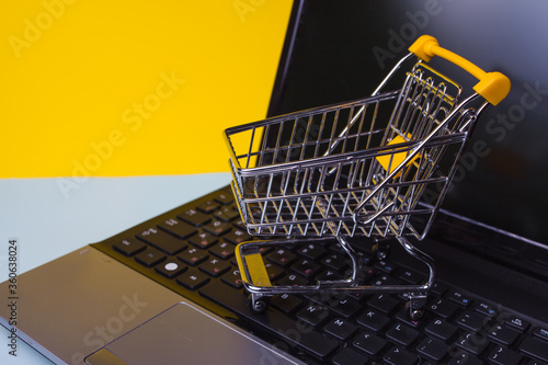 E-Commerce. Online shopping, shopping cart on laptop keyboard.