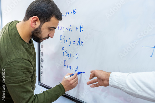 Teacher at university teaching his students how to solve mathmetics